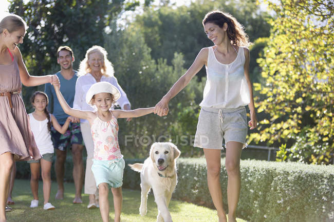 Сім'я гуляє разом у парку з собакою — стокове фото