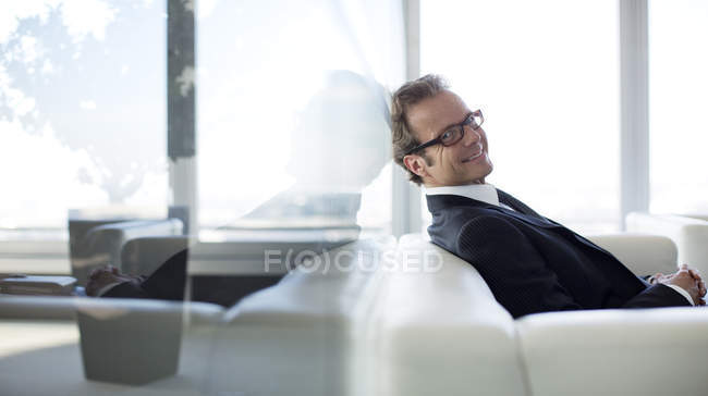 Empresário sentado no sofá no lobby do escritório — Fotografia de Stock