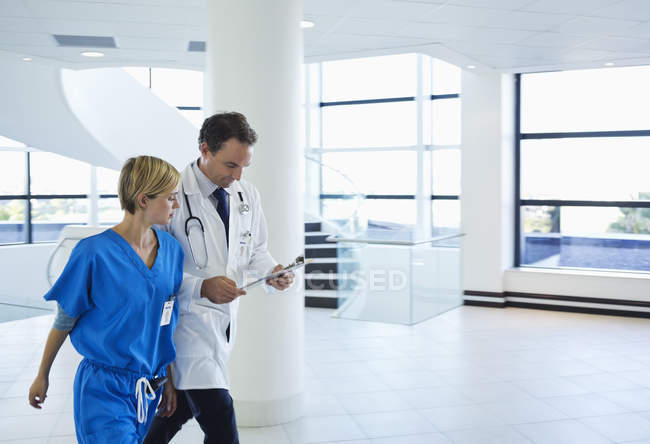 Arzt und Krankenschwester reden im Krankenhausflur — Stockfoto