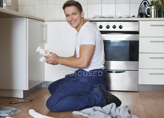 Klempner arbeitet an Rohren unter Waschbecken — Stockfoto