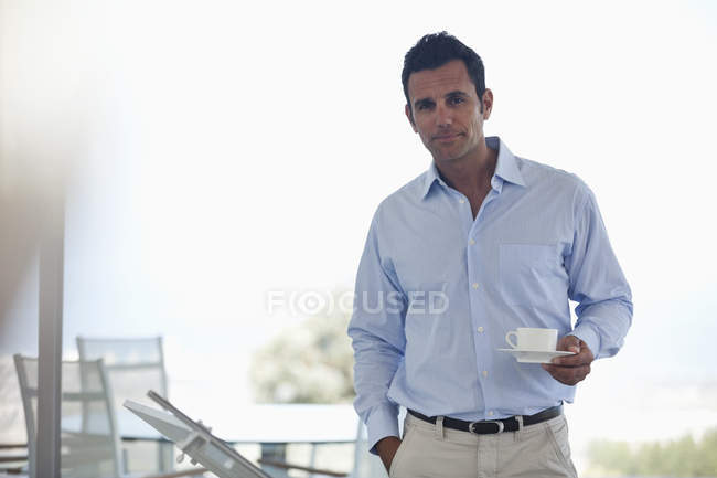Businessman having cup of coffee at modern office — Stock Photo