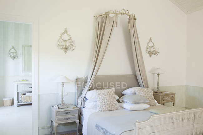 Ліжко з балдахіном в розкішній спальні — стокове фото