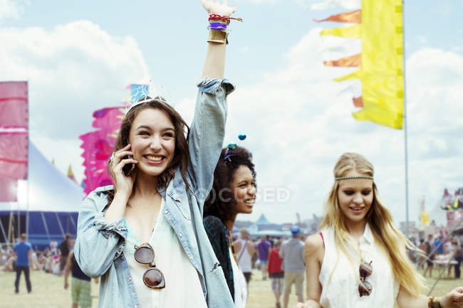 Woman talking on cell phone at music festival — Stock Photo