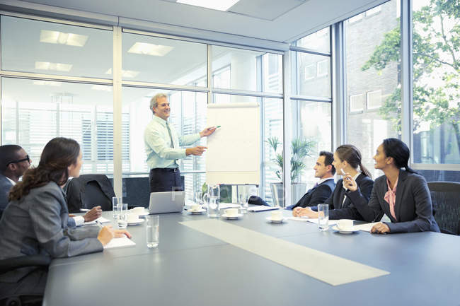 Empresário levando reunião em flipchart na sala de conferências no escritório moderno — Fotografia de Stock