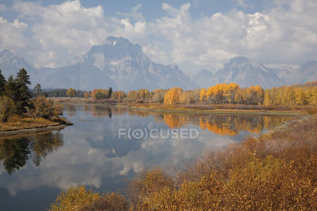 Montañas y cielo reflejados en río quieto - foto de stock