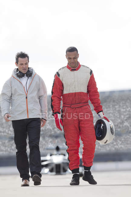 Racer and manager walking on track — Stock Photo