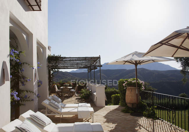 Liegestühle und Sonnenschirme auf dem Balkon des Luxushotels — Stockfoto