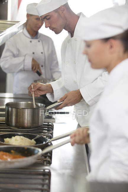Cuochi che cucinano in cucina ristorante — Foto stock