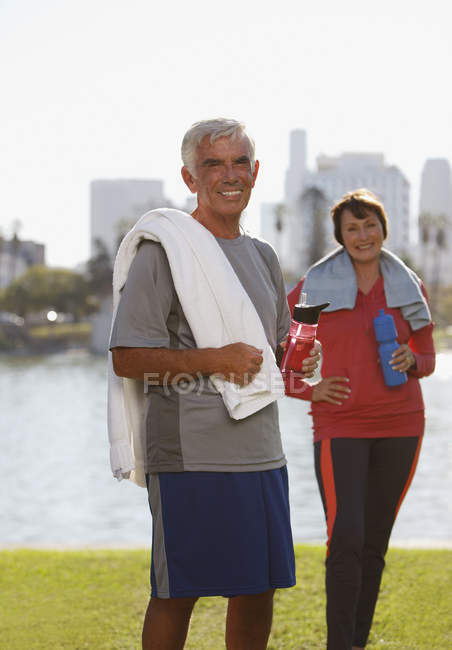Older couple drinking water after workout — Stock Photo