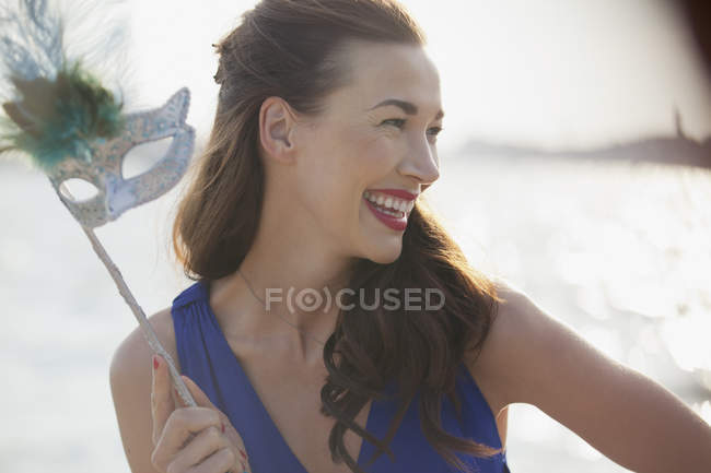 Close up of smiling woman holding mask — Stock Photo