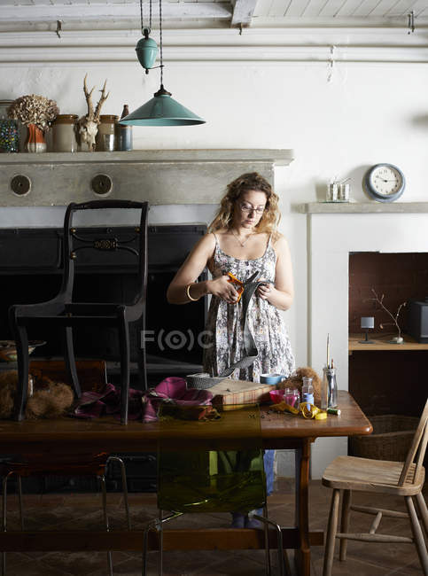 Woman decorating chair with fabric — Stock Photo