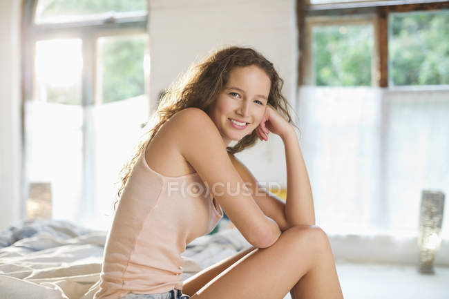 Giovane donna felice sorridente sul letto — Foto stock