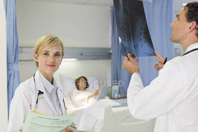 Médecins examinant les rayons X dans la chambre d'hôpital — Photo de stock