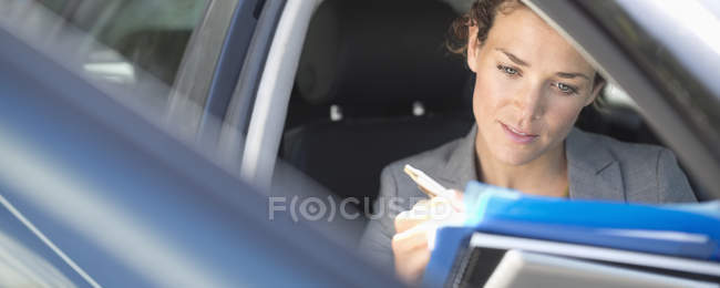 Femme d'affaires travaillant dans la voiture — Photo de stock