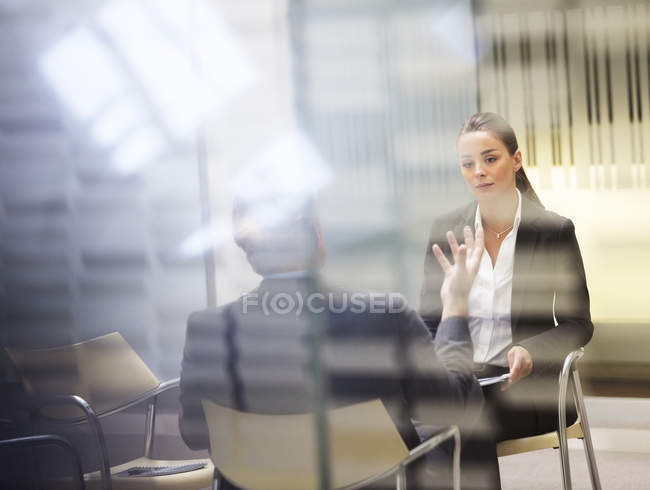Бизнесмен и деловая женщина разговаривают в современном офисе — стоковое фото
