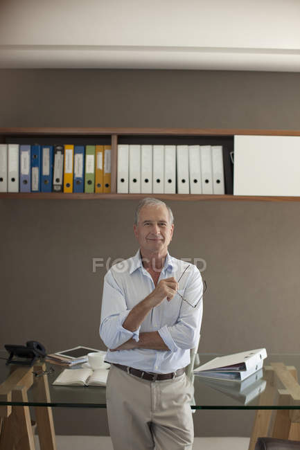 Homme plus âgé debout dans le bureau — Photo de stock