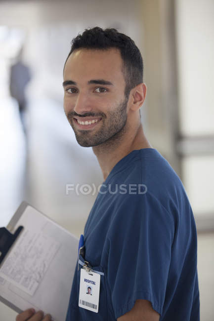 Enfermera sonriendo en el moderno pasillo del hospital - foto de stock