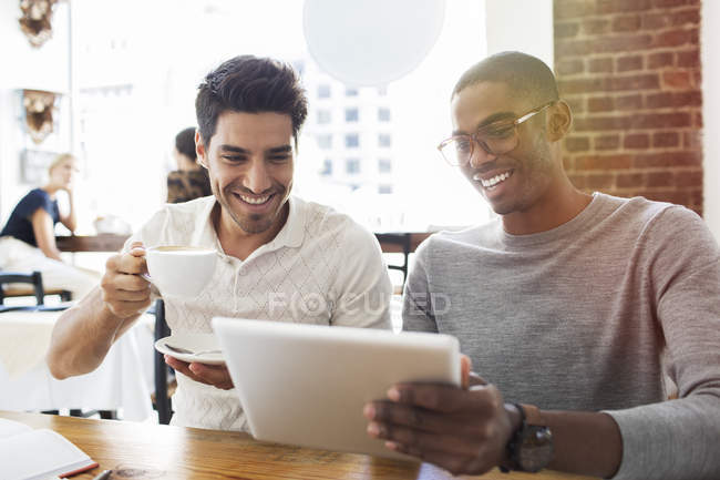 Empresarios usando tableta digital en cafetería - foto de stock