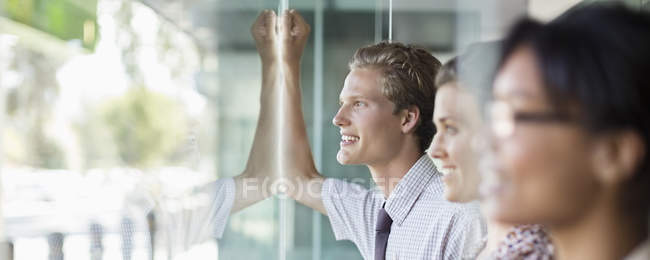 Business people looking out office window — Stock Photo
