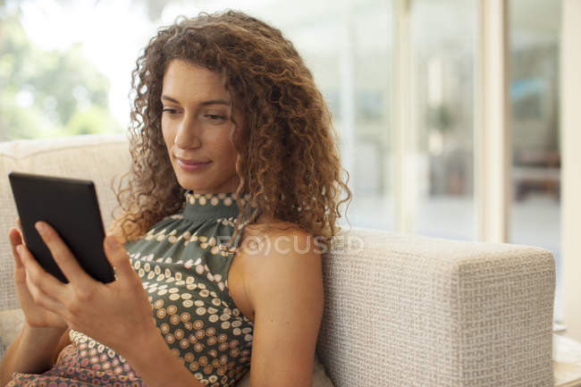 Жінка використовує планшетний комп'ютер на дивані — стокове фото