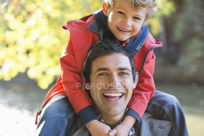 Father carrying son on shoulders in park — Stock Photo