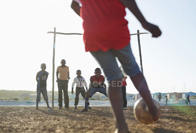 Африканські хлопчики грають у футбол разом у ґрунтовому полі — стокове фото