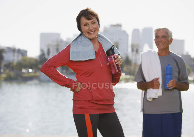 Older couple drinking water during workout — Stock Photo