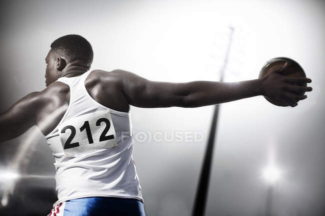 Track and field athlete throwing discus — Stock Photo