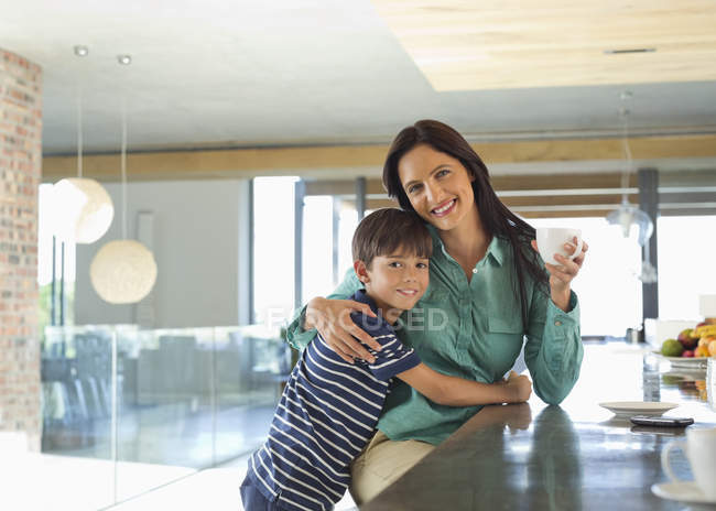 Mãe e filho sorrindo na cozinha — Fotografia de Stock
