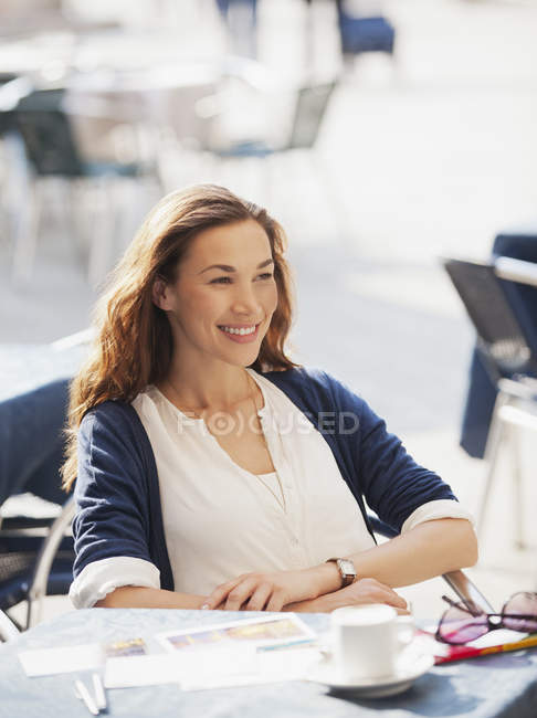 Mulher sorridente no café da calçada — Fotografia de Stock