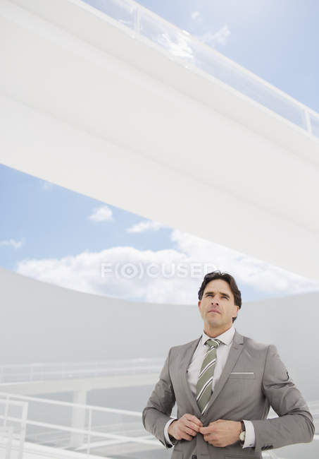 Confident businessman adjusting suit jacket — Stock Photo