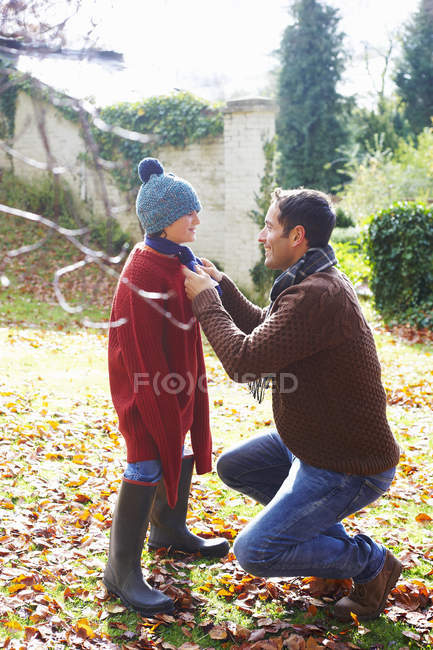Father tying son's scarf at autumn country — Stock Photo