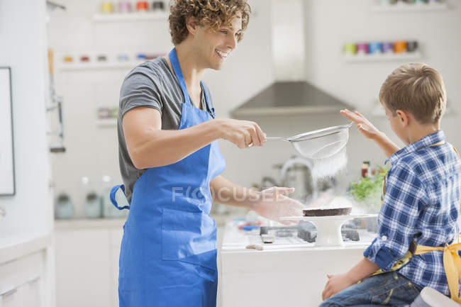 Отец и сын пекут на кухне — стоковое фото