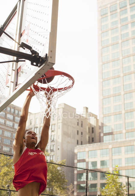 Mann beim Dunking Basketball auf dem Platz — Stockfoto