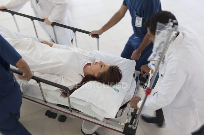 Персонал лікарні кидає пацієнта в операційну кімнату — стокове фото