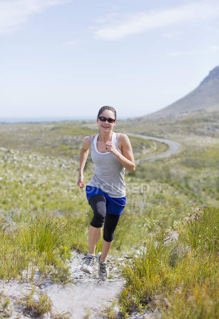 Young caucasian woman running on dirt path — Stock Photo