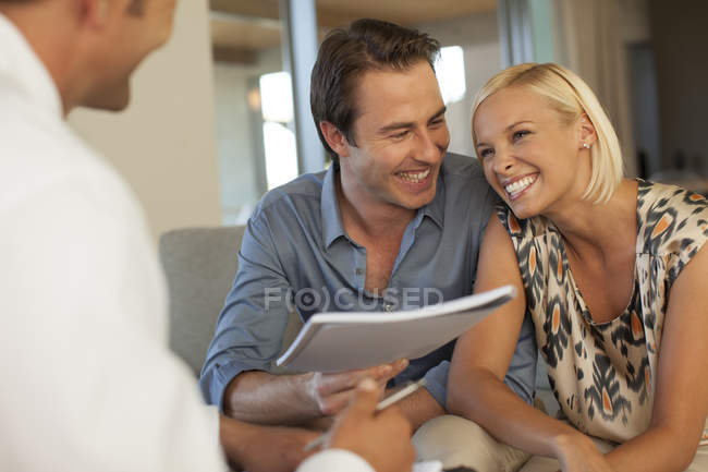 Finanzberater spricht mit Paar auf dem Sofa — Stockfoto