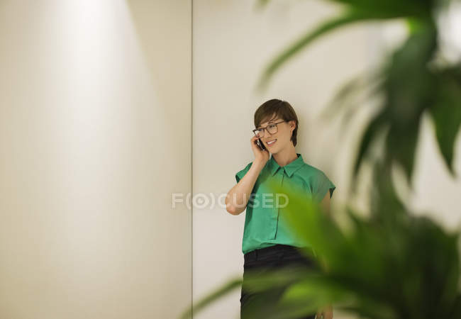 Femme d'affaires parlant sur téléphone portable au bureau moderne — Photo de stock