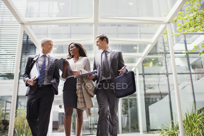 Geschäftsleute gehen gemeinsam aus Bürogebäude — Stockfoto