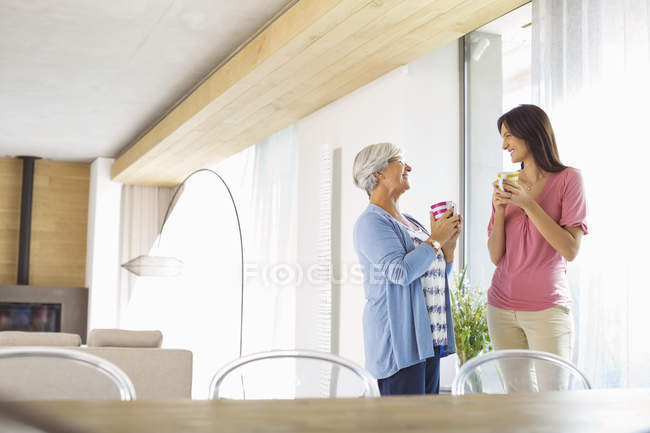 Mother and daughter having cup of coffee — Stock Photo