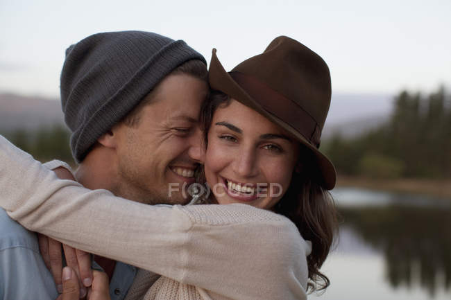 Крупним планом портрет щасливої пари, що обіймається на березі озера — стокове фото