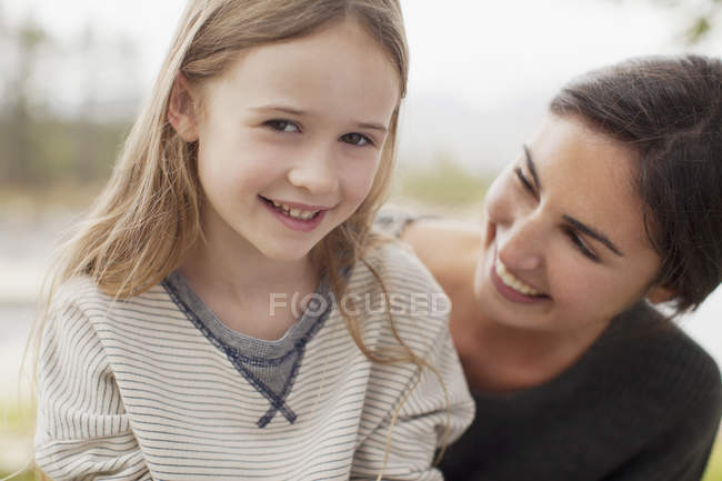 Primer plano retrato de sonriente madre e hija - foto de stock