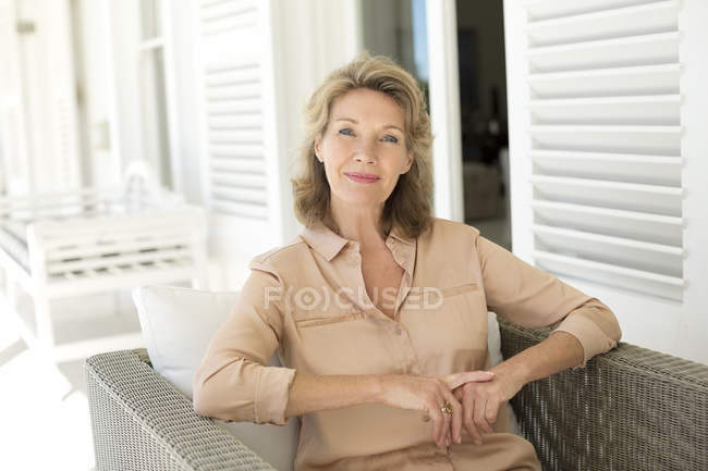 Портрет усміхненої кавказької старшої жінки, що сидить на патіо — стокове фото