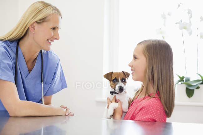 Veterinário e proprietário examinando cão em cirurgia veterinária — Fotografia de Stock