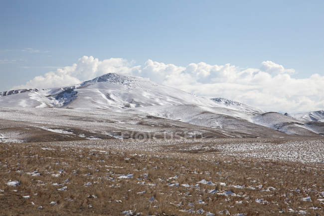 Clouds over hills in snowy landscape — Stock Photo