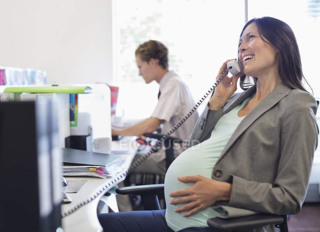 Donna d'affari incinta che parla al telefono — Foto stock