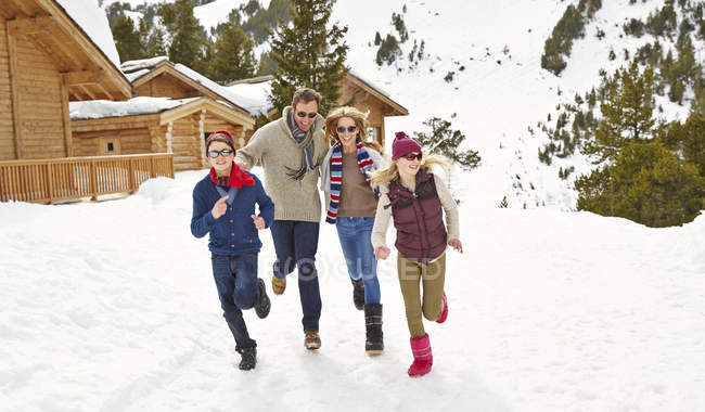 Сім'я біжить на снігу разом — стокове фото