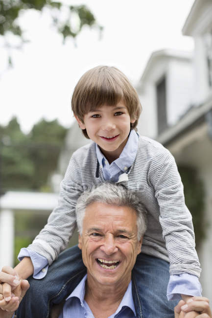 Man carrying grandson on his shoulders — Stock Photo