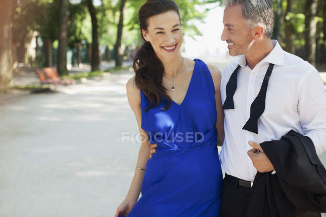 Couple souriant bien habillé dans le parc — Photo de stock