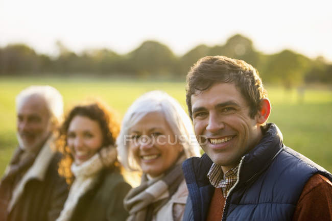 Familia feliz sonriendo juntos en el parque - foto de stock